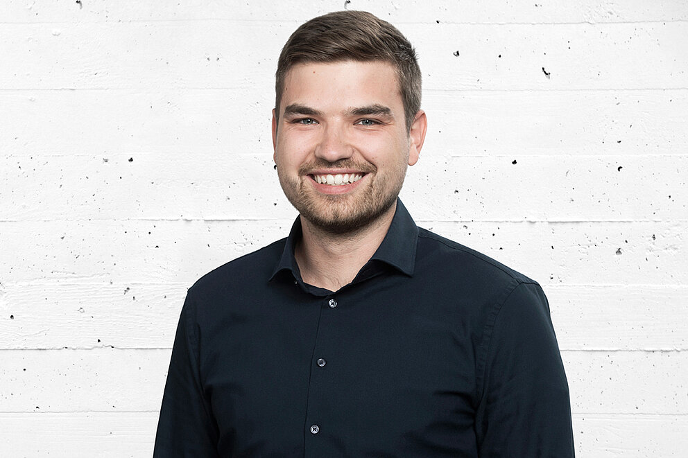 Protrait von Axel Rosenland, Mitarbeiter bei Transformationswissen BW, der lächelnd in die Kamera blickt.